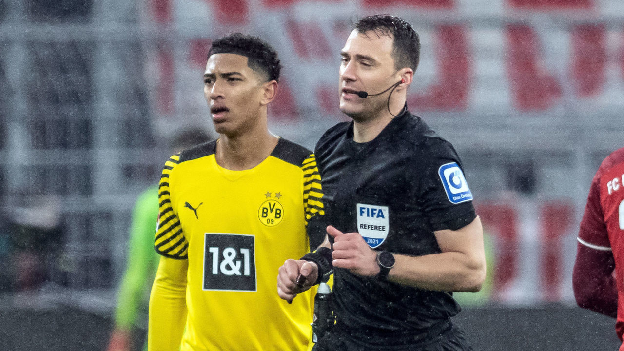 04 December 2021, North Rhine-Westphalia, Dortmund: Football, Bundesliga, Borussia Dortmund - FC Bayern München, Matchday 14 at Signal Iduna Park. Referee Felix Zwayer (r) runs past Dortmund's Jude Bellingham to the side of the pitch to watch the video evidence for the penalty kick that is subsequently given. Photo: Bernd Thissen/dpa - IMPORTANT NOTE: In accordance with the regulations of the DFL Deutsche Fußball Liga and/or the DFB Deutscher Fußball-Bund, it is prohibited to use or have used photographs taken in the stadium and/or of the match in the form of sequence pictures and/or video-like photo series.
