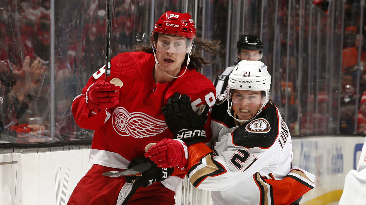 ANAHEIM, CA - JANUARY 9: Isac Lundestrom #21 of the Anaheim Ducks battles for position against Tyler Bertuzzi #59 of the Detroit Red Wings during the game at Honda Center on January 9, 2022 in Anaheim, California.