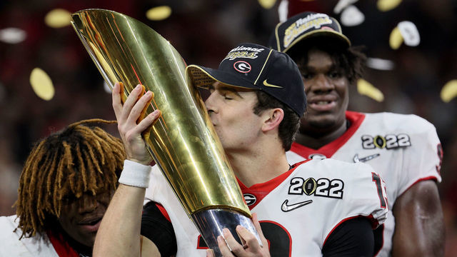 INDIANAPOLIS, INDIANA - JANUARY 10: Stetson Bennett #13 of the Georgia Bulldogs celebrates with the National Championship trophy after the Georgia Bulldogs defeated the Alabama Crimson Tide 33-18 during the 2022 CFP National Championship Game at Lucas Oil Stadium on January 10, 2022 in Indianapolis, Indiana.