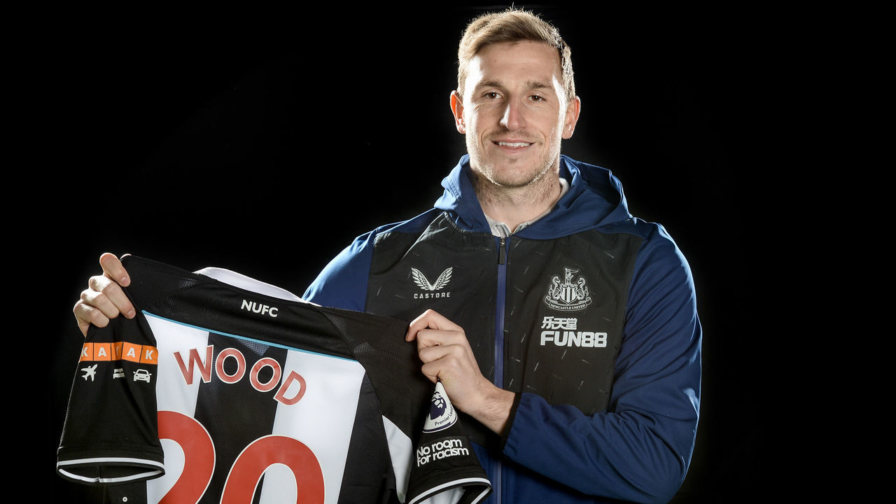 NEWCASTLE UPON TYNE, ENGLAND - JANUARY 13: Chris Wood poses for photographs holding his numbered shirt at the Newcastle United Training Centre on January 13, 2022 in Newcastle upon Tyne, England.