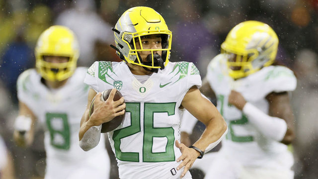 SEATTLE, WASHINGTON - NOVEMBER 06: Travis Dye #26 of the Oregon Ducks carries the ball against the Washington Huskies during the third quarter at Husky Stadium on November 06, 2021 in Seattle, Washington.