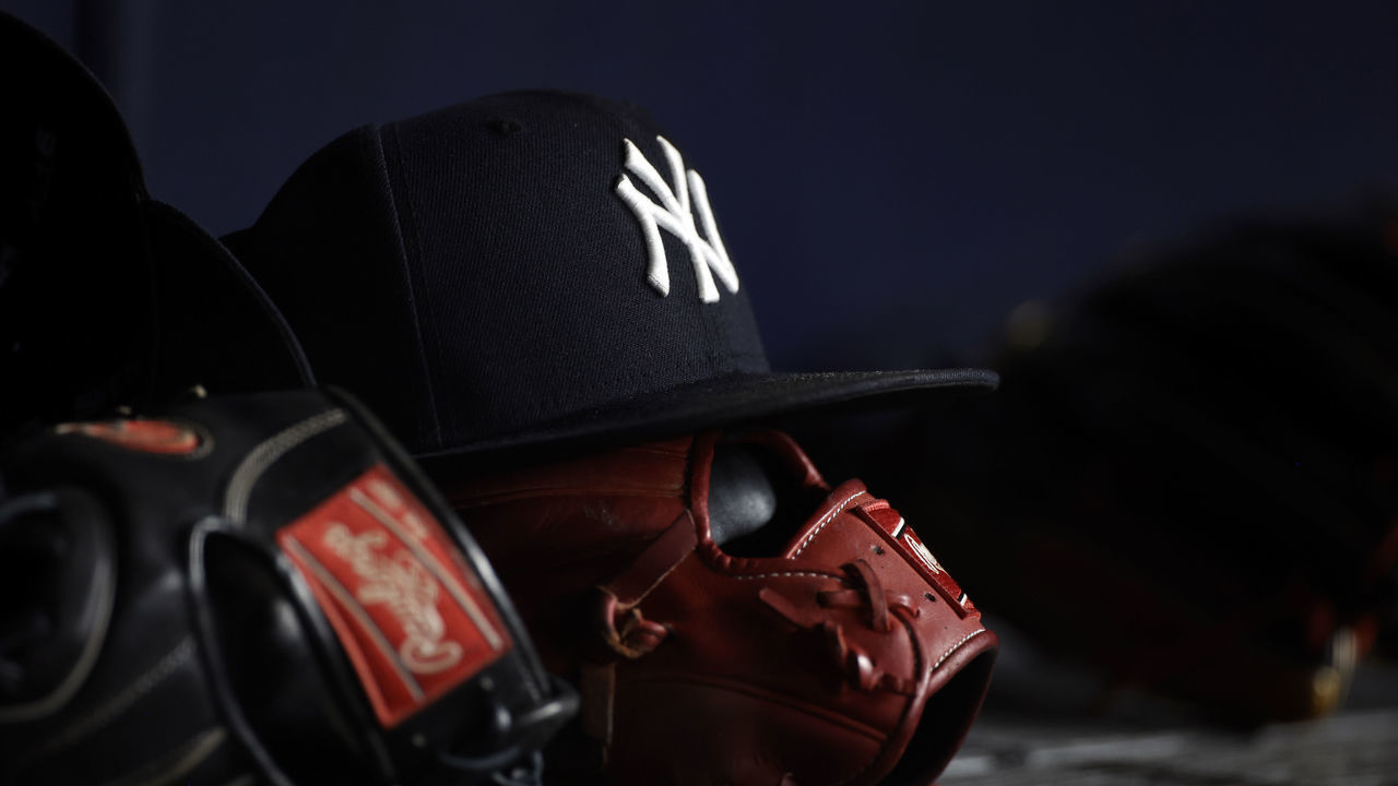 NEW YORK, NY - JUNE 6: A New York Yankees baseball hat sits on top of a glove in the Yankee dugout against the Boston Red Sox during the eighth inning at Yankee Stadium on June 6, 2021 in the Bronx borough of New York City.