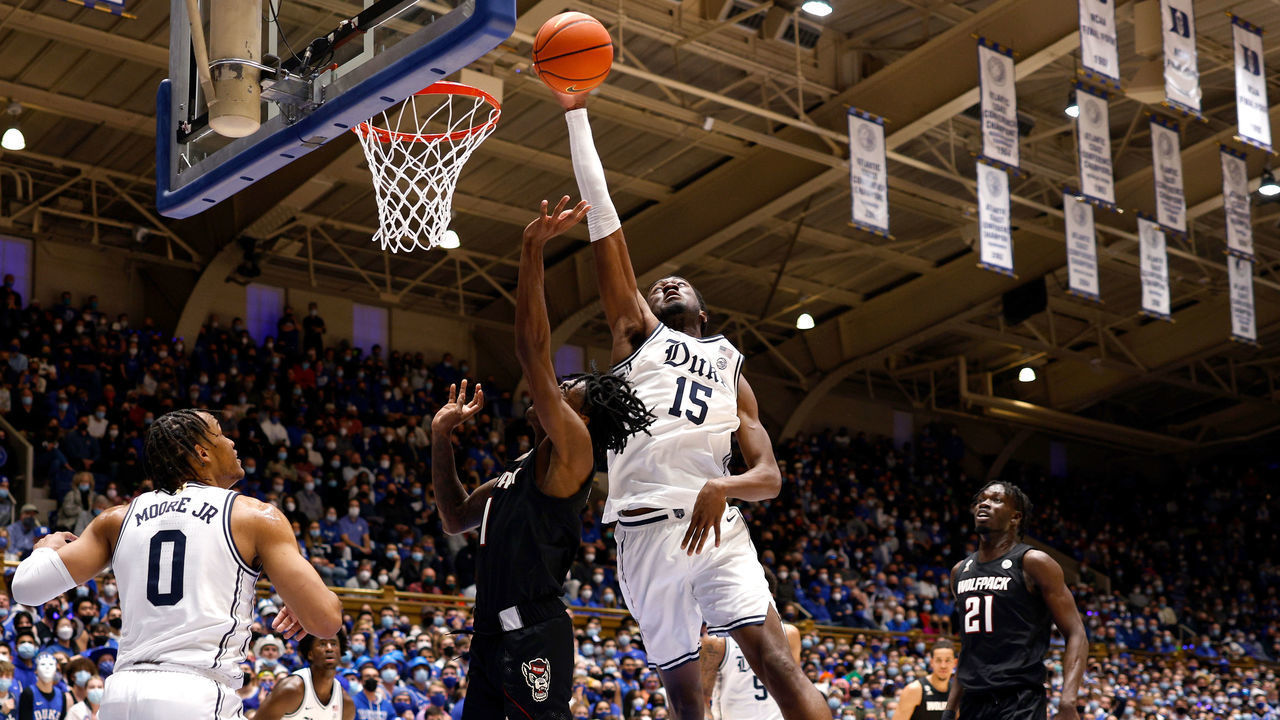 DURHAM, NC - JANUARY 15: Mark Williams #15 of the Duke Blue Devils blocks a shot by Dereon Seabron #1 of the North Carolina State Wolfpack in the first half at Cameron Indoor Stadium on January 15, 2022 in Durham, North Carolina.