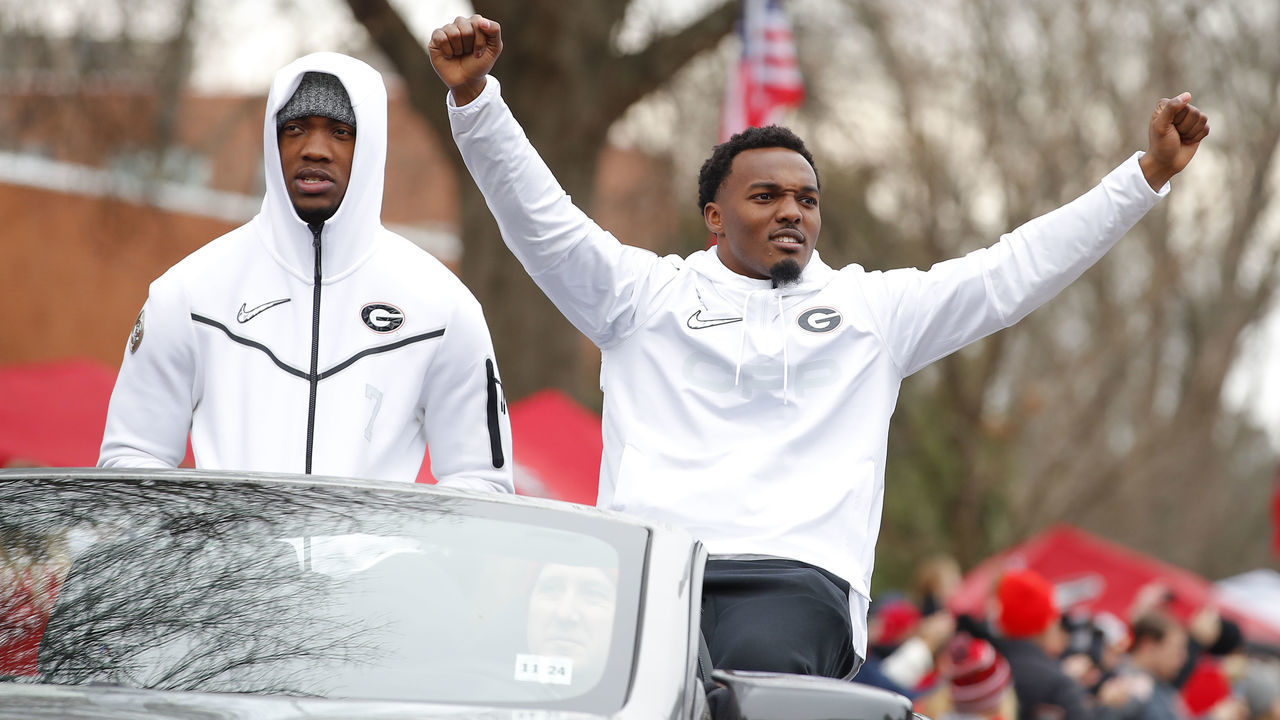 ATHENS, GA - JANUARY 15: Quay Walker #7 (L) and Nakobe Dean #17 of the Georgia Bulldogs ride along during the parade honoring the Georgia Bulldogs national championship victory on January 15, 2022 in Athens, Georgia.