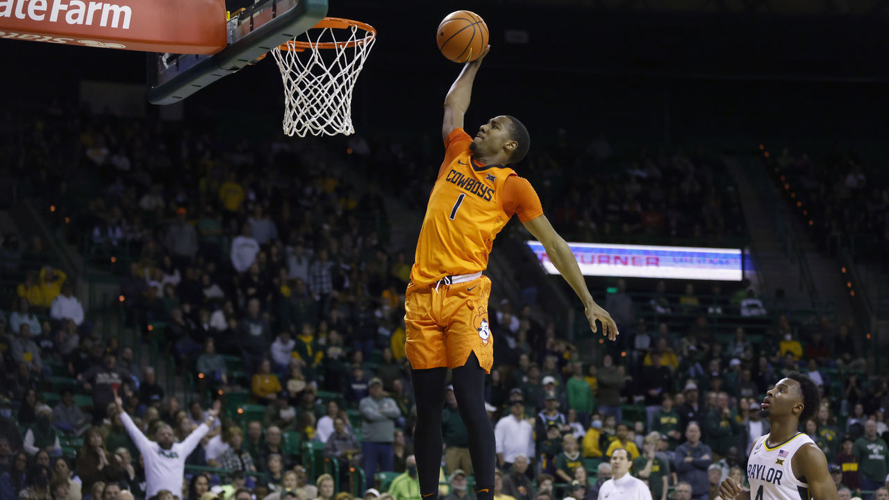 WACO, TX - JANUARY 15: Bryce Thompson #1 of the Oklahoma State Cowboys goes up for a break away slam dunk as LJ Cryer #4 of the Baylor Bears looks on in the first half at the Ferrell Center on January 15, 2022 in Waco, Texas.