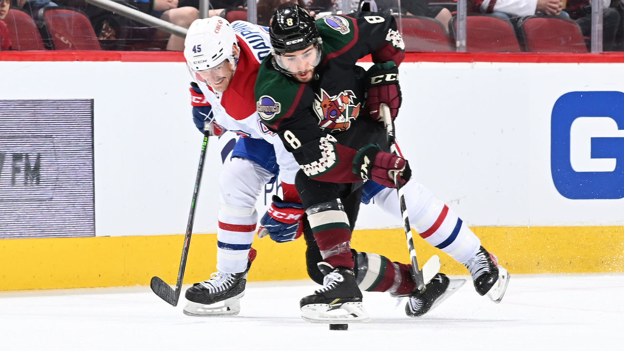 GLENDALE, ARIZONA - JANUARY 17: Nick Schmaltz #8 of the Arizona Coyotes skates with the puck while being defended by Laurent Dauphin #45 of the Montreal Canadiens during the third period at Gila River Arena on January 17, 2022 in Glendale, Arizona.