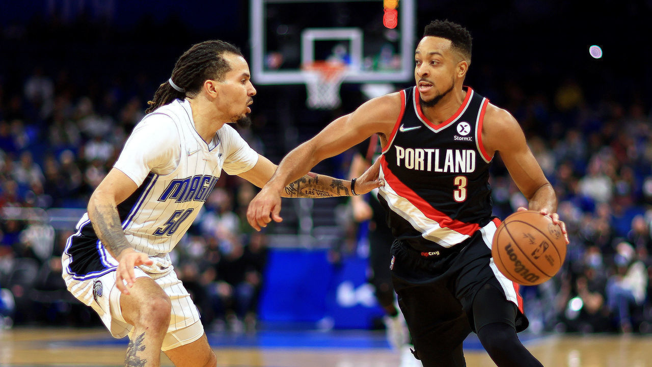 ORLANDO, FLORIDA - JANUARY 17: CJ McCollum #3 of the Portland Trail Blazers drives on Cole Anthony #50 of the Orlando Magic during a game at Amway Center on January 17, 2022 in Orlando, Florida.