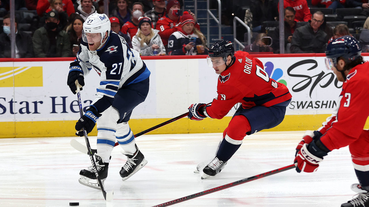 WASHINGTON, DC - JANUARY 18: Nikolaj Ehlers #27 of the Winnipeg Jets skates with puck against Dmitry Orlov #9 and Nick Jensen #3 of the Washington Capitals in the first period at Capital One Arena on January 18, 2022 in Washington, DC.