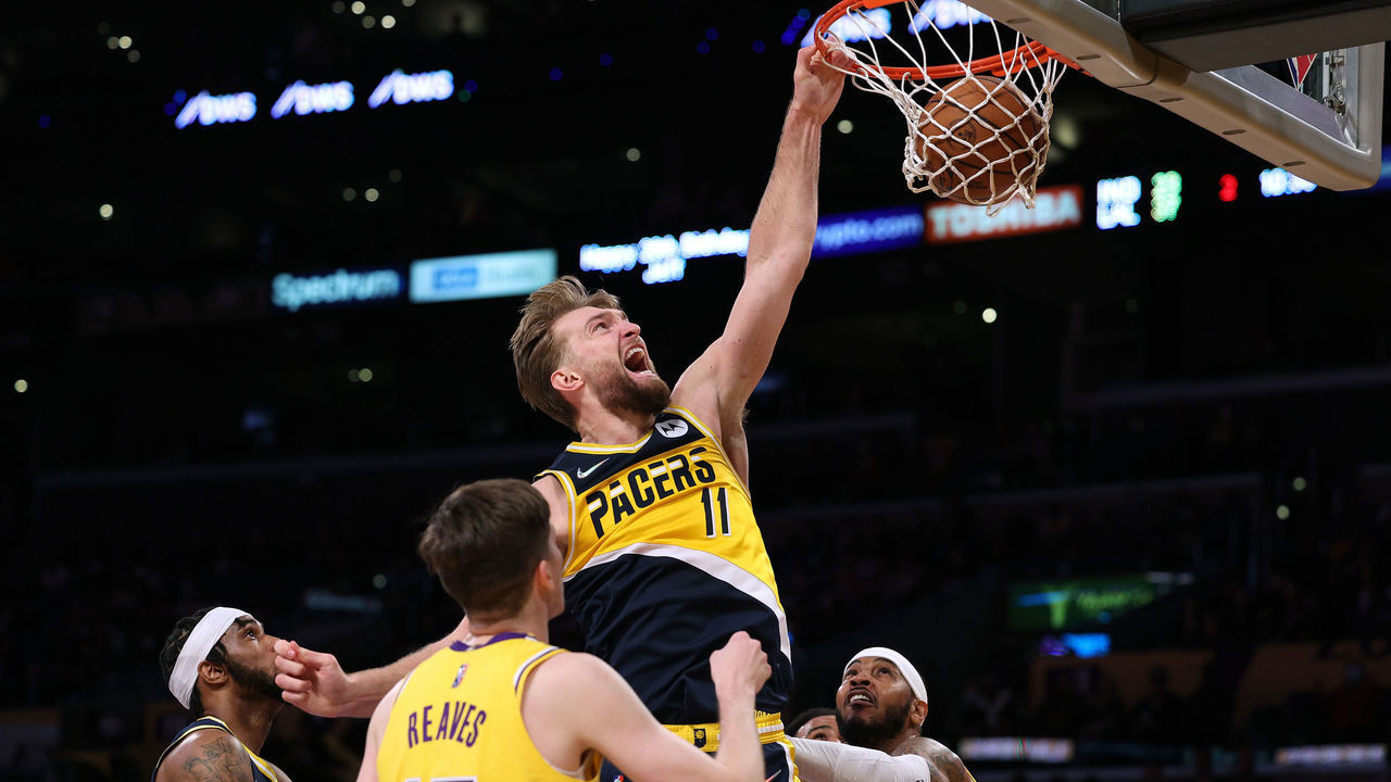 LOS ANGELES, CALIFORNIA - JANUARY 19: Domantas Sabonis #11 of the Indiana Pacers reacts as he dunks between Carmelo Anthony #7 and Austin Reaves #15 of the Los Angeles Lakers during the first half at Crypto.com Arena on January 19, 2022 in Los Angeles, California. NOTE TO USER: User expressly acknowledges and agrees that, by downloading and/or using this Photograph, user is consenting to the terms and conditions of the Getty Images License Agreement. Mandatory Copyright Notice: Copyright 2022 NBAE