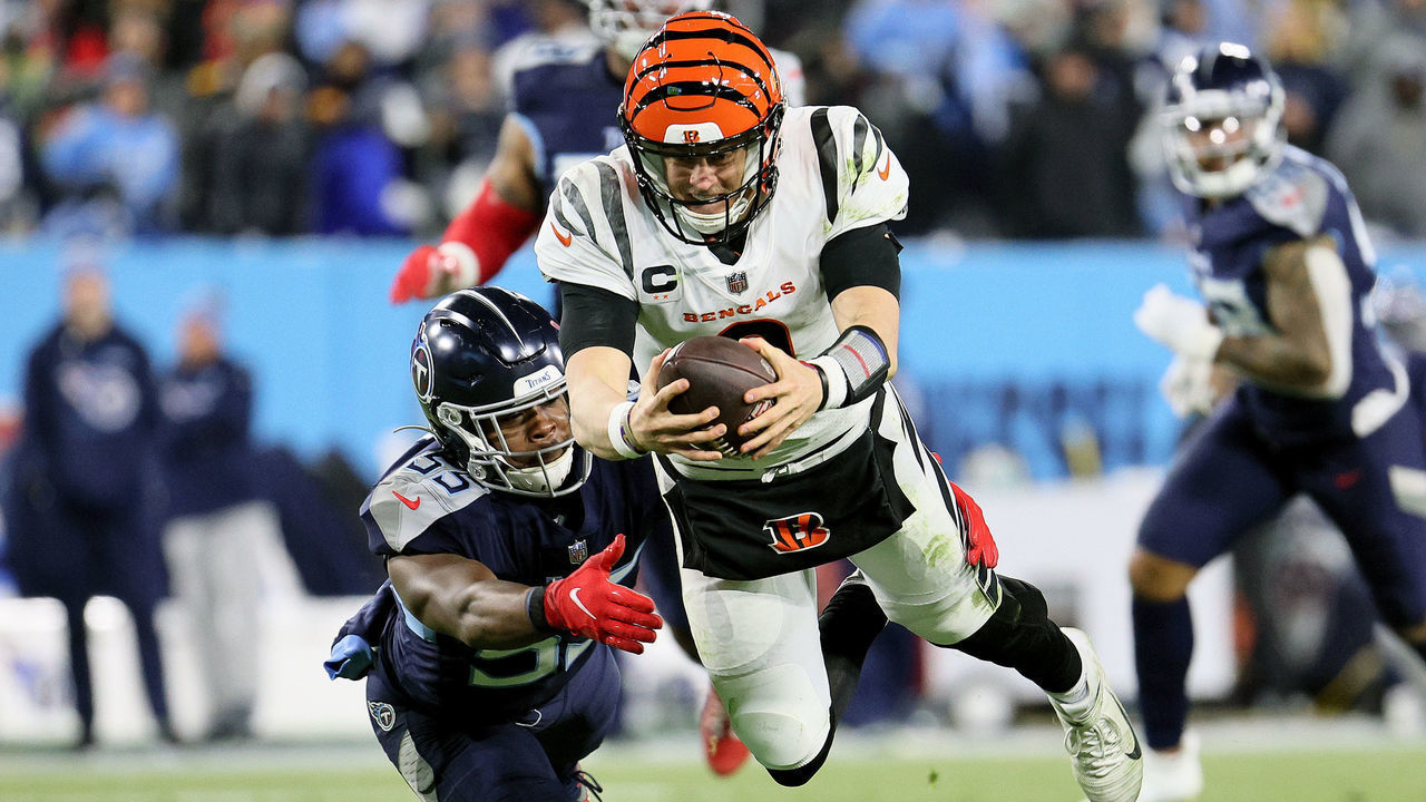 NASHVILLE, TENNESSEE - JANUARY 22: Quarterback Joe Burrow #9 of the Cincinnati Bengals dives for a third quarter first down in front of inside linebacker Jayon Brown #55 of the Tennessee Titans in the AFC Divisional Playoff game at Nissan Stadium on January 22, 2022 in Nashville, Tennessee.