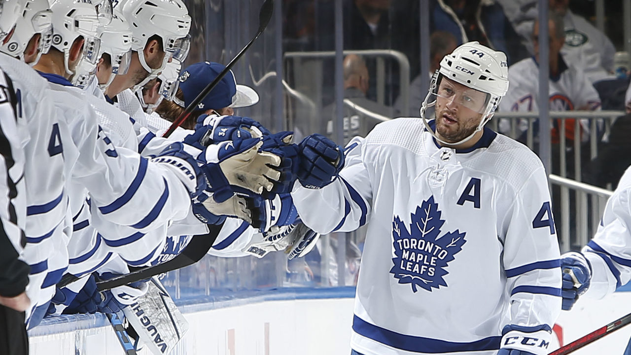 ELMONT, NY - JANUARY 22: Morgan Rielly #44 of the Toronto Maple Leafs is congratulated as he returns to the bench after scoring a second period goal against the New York Islanders at UBS Arena on January 22, 2022 in Elmont, New York.