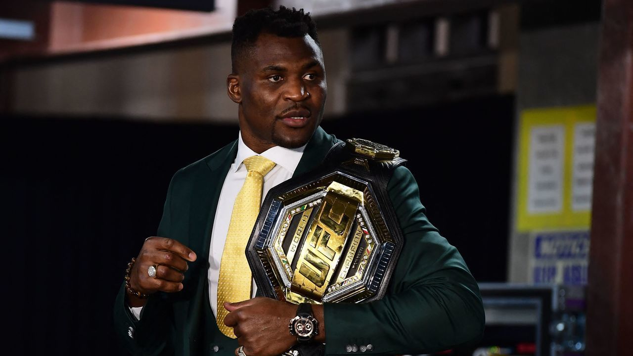Champion Cameroon's Francis Ngannou holds the championship belt in the press room after defeating French Cyril Gane in their UFC 270 championship fight in Anaheim on January 22, 2022.