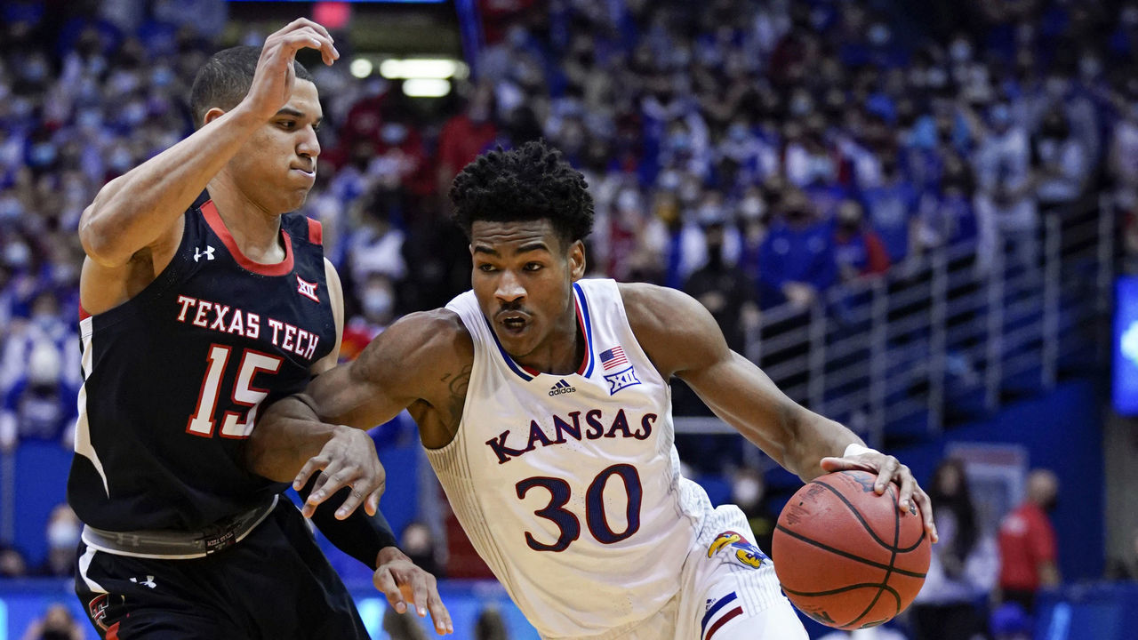 LAWRENCE, KANSAS - JANUARY 24: Ochai Agbaji #30 of the Kansas Jayhawks drives against Kevin McCullar #15 of the Texas Tech Red Raiders during the first half at Allen Fieldhouse on January 24, 2022 in Lawrence, Kansas.