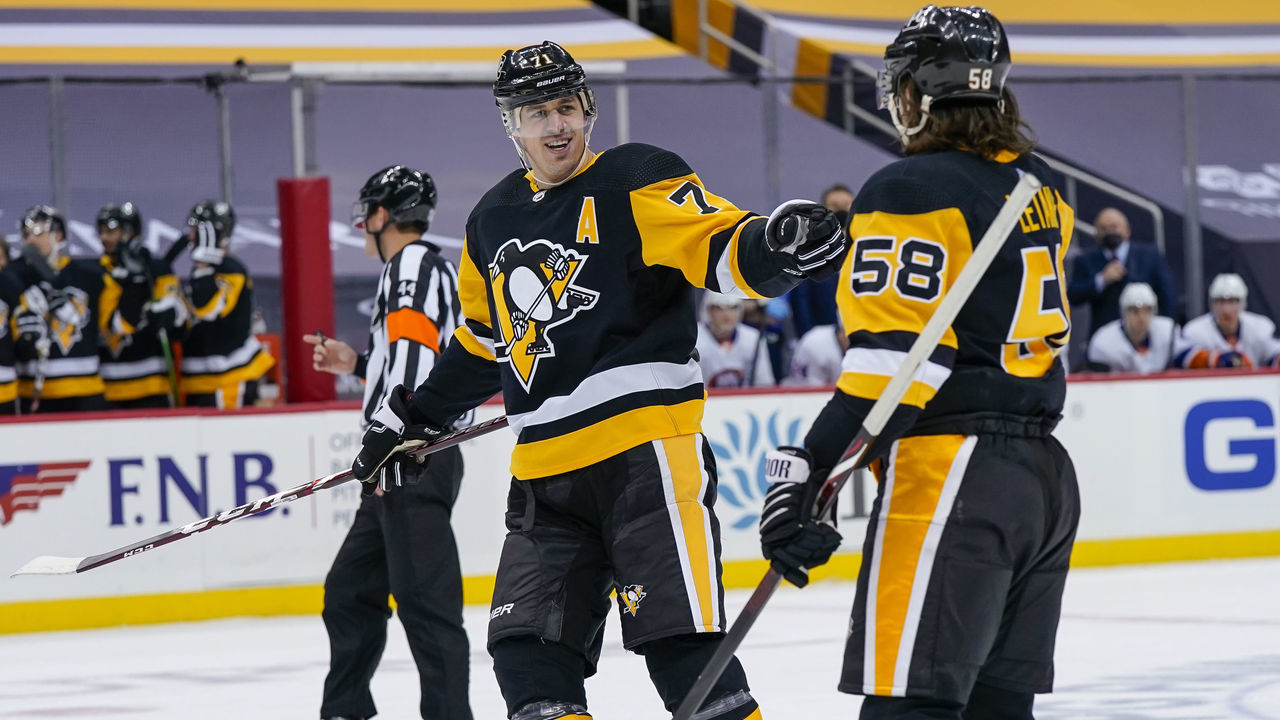 PITTSBURGH, PA - FEBRUARY 20: Pittsburgh Penguins Defenceman Kris Letang (58) celebrates his goal with Pittsburgh Penguins Center Evgeni Malkin (71) during the second period in the NHL game between the Pittsburgh Penguins and the New York Islanders on February 20, 2021, at PPG Paints Arena in Pittsburgh, PA.