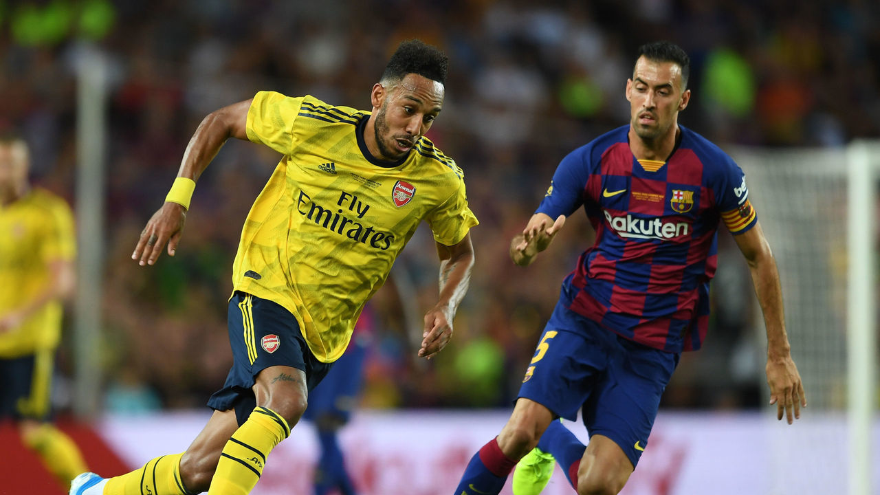 BARCELONA, SPAIN - AUGUST 04: Pierre-Emerick Aubameyang of Arsenal takes on Sergio Busquets of Barcleona during the match between FC Barcelona and Arsenal at Nou Camp on August 04, 2019 in Barcelona, Spain.