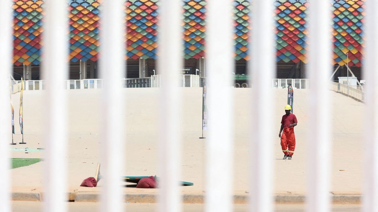 A worker walks near the entrance of Olembe stadium in Yaounde at the scene of the stampede on January 25, 2022. - Eight people were killed and many more injured in a crush outside a Cameroonian football stadium on January 24, 2022 ahead of an Africa Cup of Nations match. Crowds attempted to enter through a southern entrace at Olembe stadium in the capital Yaounde to watch the host nation play Comoros.