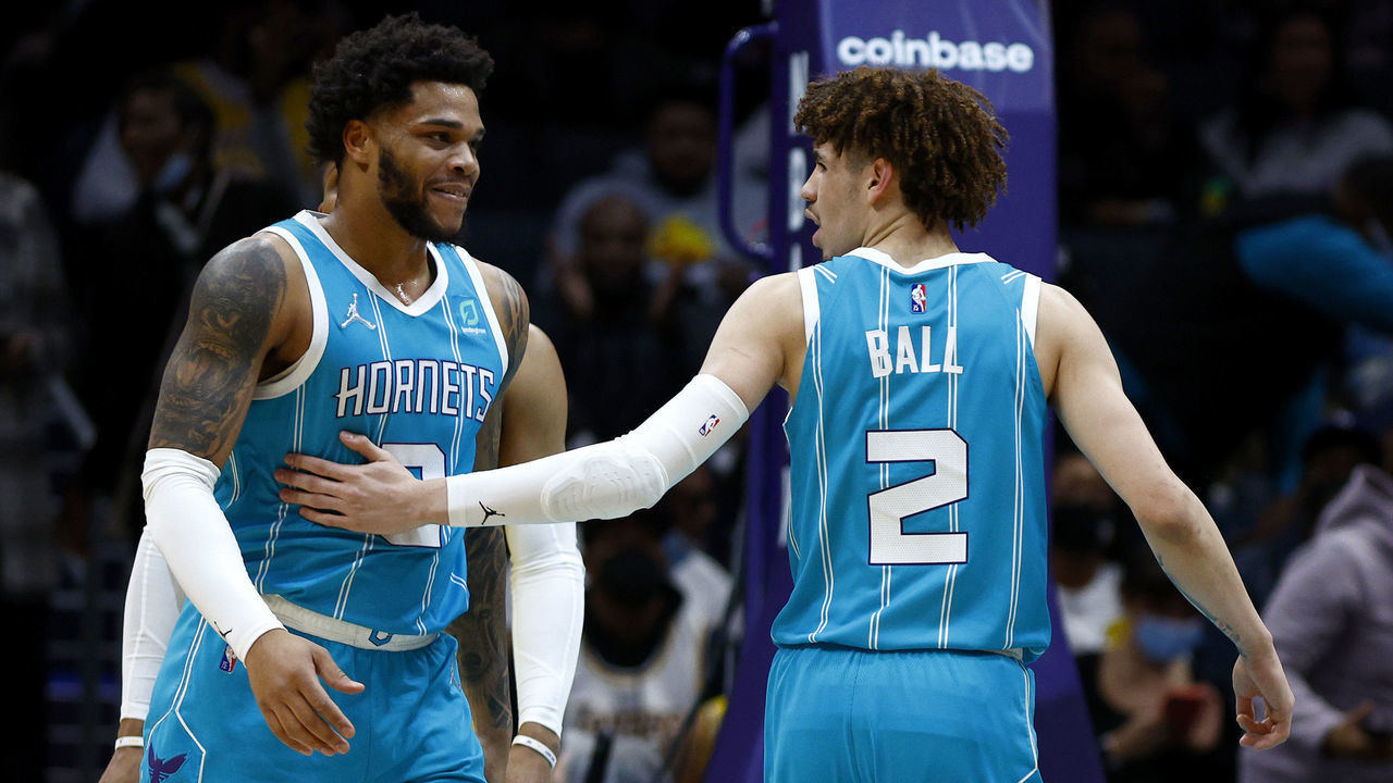 CHARLOTTE, NORTH CAROLINA - JANUARY 28: LaMelo Ball #2 of the Charlotte Hornets reacts with Miles Bridges #0 following a basket during the first half of the game against the Los Angeles Lakers at Spectrum Center on January 28, 2022 in Charlotte, North Carolina.