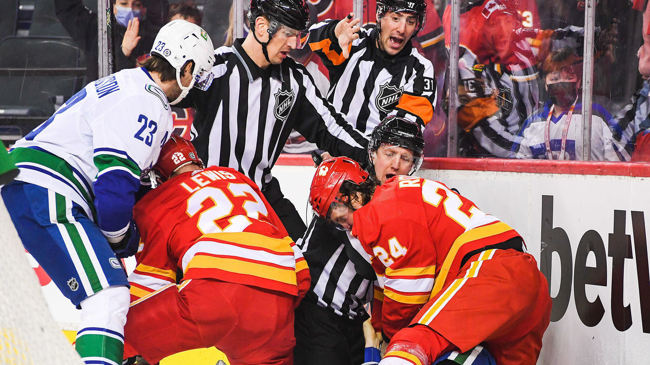 CALGARY, AB - JANUARY 29: Brett Ritchie #24 of the Calgary Flames fights Tyler Myers #57 of the Vancouver Canucks after Myers checked Ritchie's teammate Trevor Lewis #22 (not pictured) during an NHL game at Scotiabank Saddledome on January 29, 2022 in Calgary, Alberta, Canada.