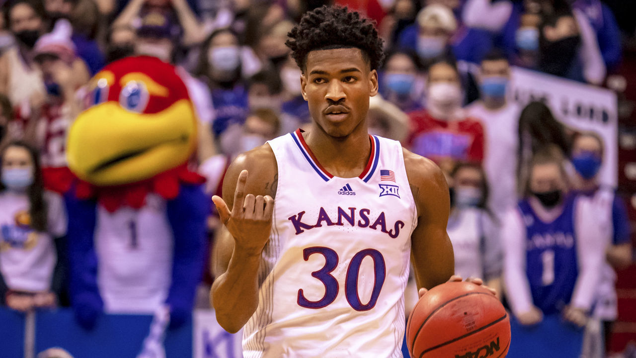 LAWRENCE, KS - JANUARY 29: Ochai Agbaji #30 of the Kansas Jayhawks drives the ball forward against the Kentucky Wildcats in the first half at Allen Fieldhouse on January 29, 2022 in Lawrence, Kansas.