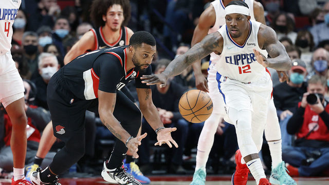 PORTLAND, OREGON - DECEMBER 06: Norman Powell # 24 of the Portland Trail Blazers passes the ball as Eric Bledsoe # 12 of the Los Angeles Clippers defense during the second half at Moda Center on December 06, 2021 in Portland, Oregon.