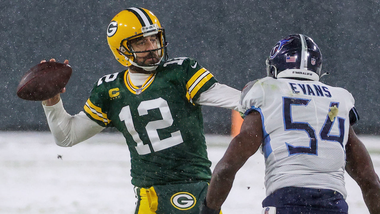 GREEN BAY, WISCONSIN - DECEMBER 27: Aaron Rodgers #12 of the Green Bay Packers throws a pass while being chased by Rashaan Evans #54 of the Tennessee Titans in the first quarter at Lambeau Field on December 27, 2020 in Green Bay, Wisconsin.