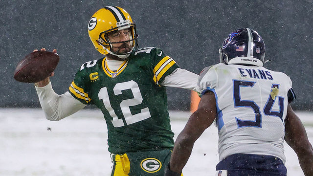 GREEN BAY, WISCONSIN - DECEMBER 27: Aaron Rodgers #12 of the Green Bay Packers throws a pass while being chased by Rashaan Evans #54 of the Tennessee Titans in the first quarter at Lambeau Field on December 27, 2020 in Green Bay, Wisconsin.