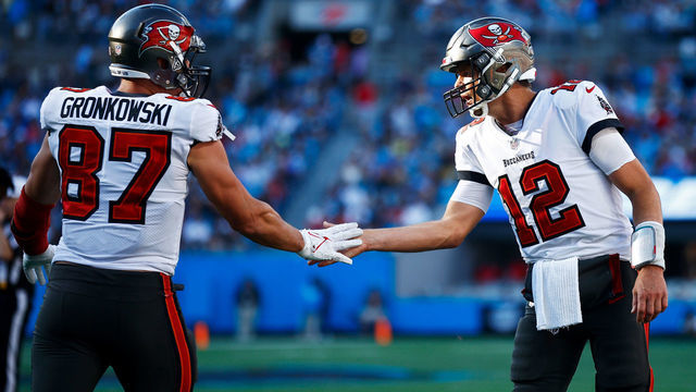 CHARLOTTE, NORTH CAROLINA - DECEMBER 26: Tom Brady #12 and Rob Gronkowski #87 of the Tampa Bay Buccaneers react after a touchdown during the third quarter in the game against the Carolina Panthers at Bank of America Stadium on December 26, 2021 in Charlotte, North Carolina.