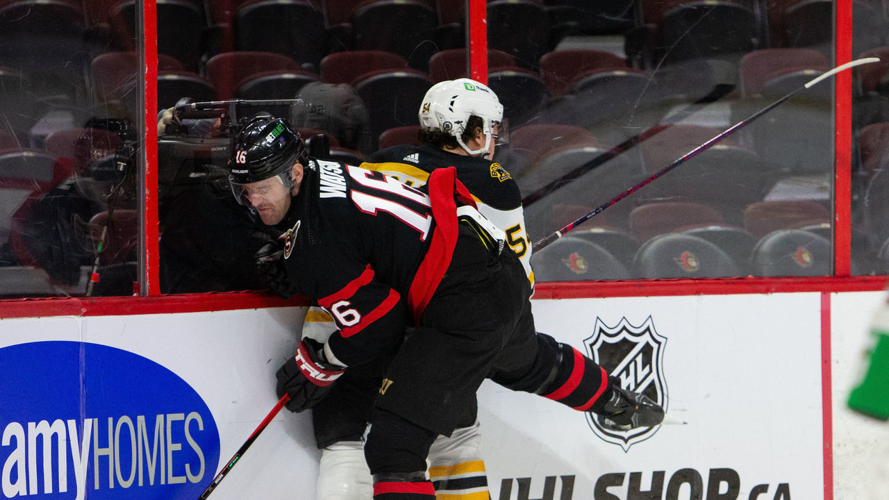 OTTAWA, ON - FEBRUARY 12: Austin Watson #16 of the Ottawa Senators bodychecks Jack Ahcan #54 of the Boston Bruins during the first period at Canadian Tire Centre on February 12, 2022 in Ottawa, Ontario, Canada.