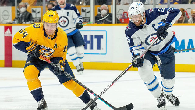 NASHVILLE, TN - FEBRUARY 12: Mikael Granlund #64 of the Nashville Predators battles for the puck against Blake Wheeler #26 of the Winnipeg Jets during an NHL game at Bridgestone Arena on February 12, 2022 in Nashville, Tennessee.
