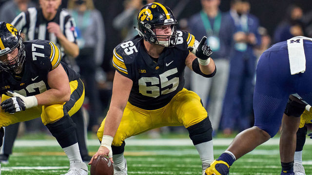 INDIANAPOLIS, IN - DECEMBER 04: Iowa Hawkeyes offensive lineman Tyler Linderbaum (65) points downfield during the Big Ten Championship Game between the Iowa Hawkeyes and the Michigan Wolverines on December 04, 2021, at Lucas Oil Stadium, in Indianapolis, IL.