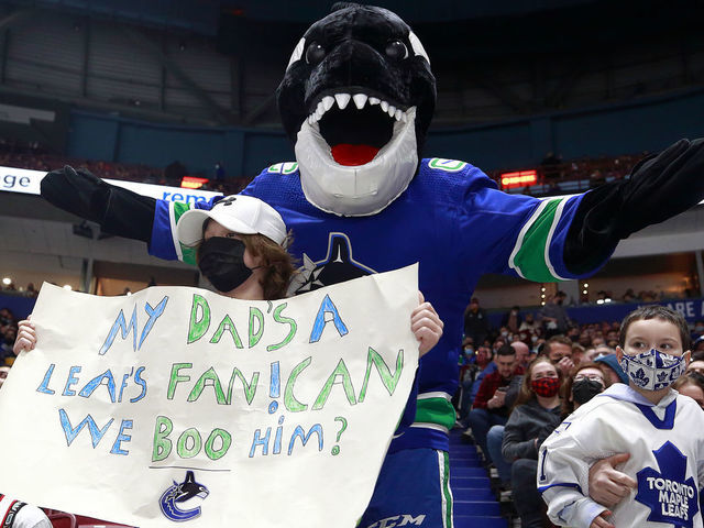 VANCOUVER, BC - FEBRUARY 12: Canucks mascot Fin and a young fan hold up a sign during the NHL game between the Vancouver Canucks and the Toronto Maple Leafs at Rogers Arena February 12, 2022 in Vancouver, British Columbia, Canada.