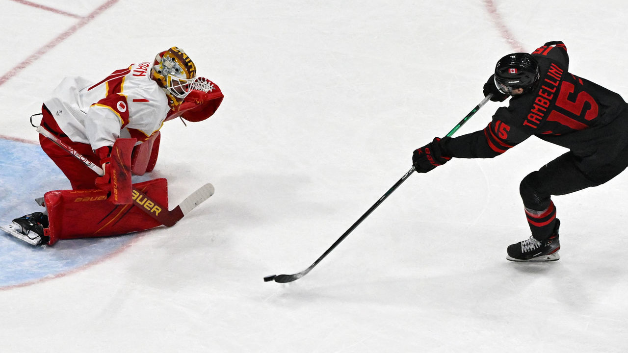 Canada's Adam Tambellini (R) scores the team's fourth goal past China's goaltender Paris O'Brien during their men's qualification play-off match of the Beijing 2022 Winter Olympic Games ice hockey competition, at the National Indoor Stadium in Beijing on February 15, 2022.