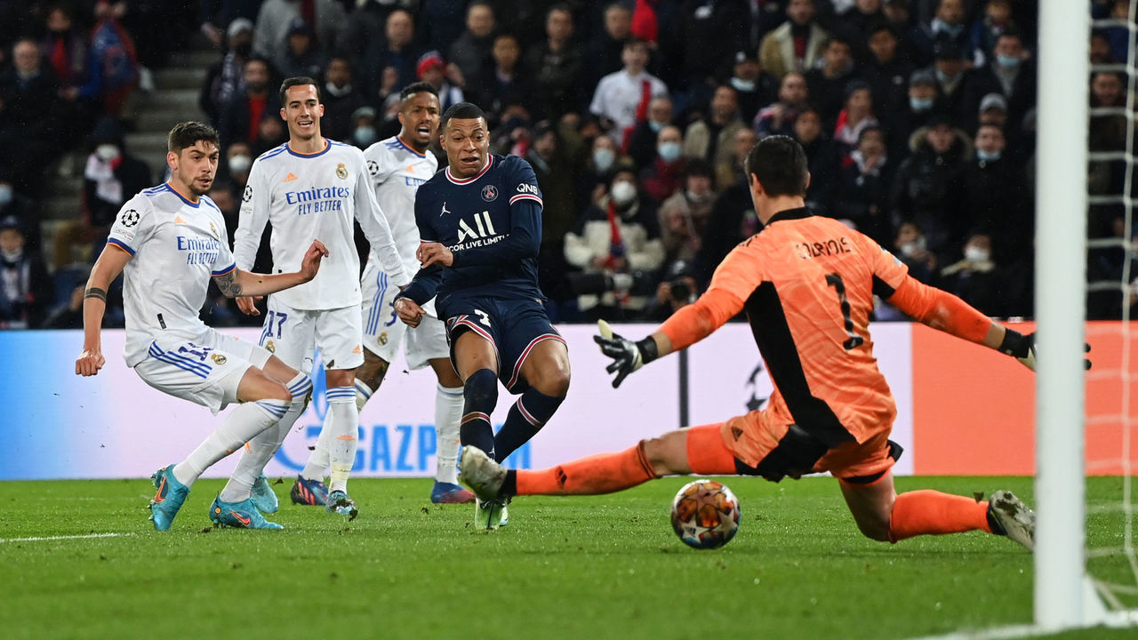 PARIS, FRANCE - FEBRUARY 15: Kylian Mbappe of Paris Saint-Germain scores their team's first goal past Thibaut Courtois of Real Madrid during the UEFA Champions League Round Of Sixteen Leg One match between Paris Saint-Germain and Real Madrid at Parc des Princes on February 15, 2022 in Paris, France.