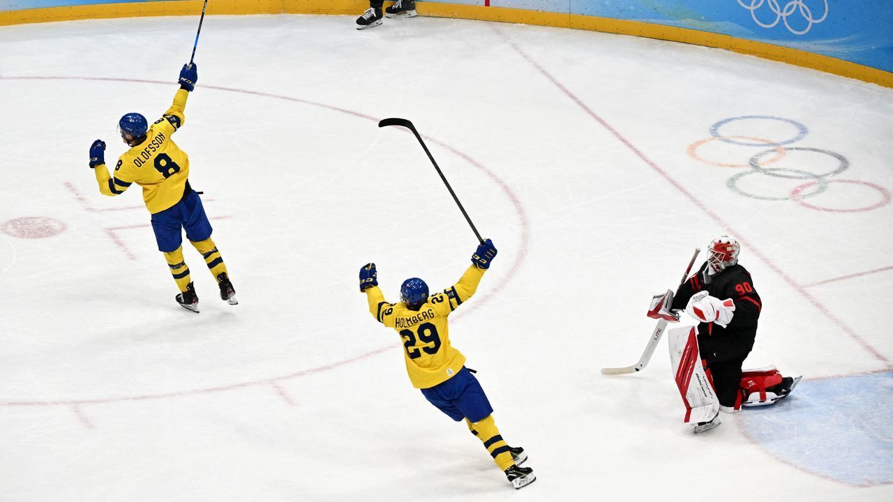 Sweden's Fredrik Olofsson (L) and Pontus Holmberg celebrate after teammate Lucas Wallmark (out of frame) scored a goal against Canada during their men's play-off quarterfinal match of the Beijing 2022 Winter Olympic Games ice hockey competition, at the National Indoor Stadium in Beijing on February 16, 2022.