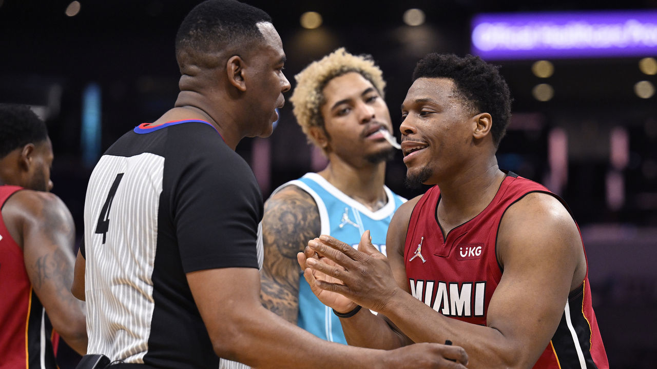 CHARLOTTE, NORTH CAROLINA - FEBRUARY 17: Kelly Oubre Jr. #12 of the Charlotte Hornets listens as Kyle Lowry #7 of the Miami Heat pleads for a foul with referee Sean Wright #4 during the first half of their game at Spectrum Center on February 17, 2022 in Charlotte, North Carolina.