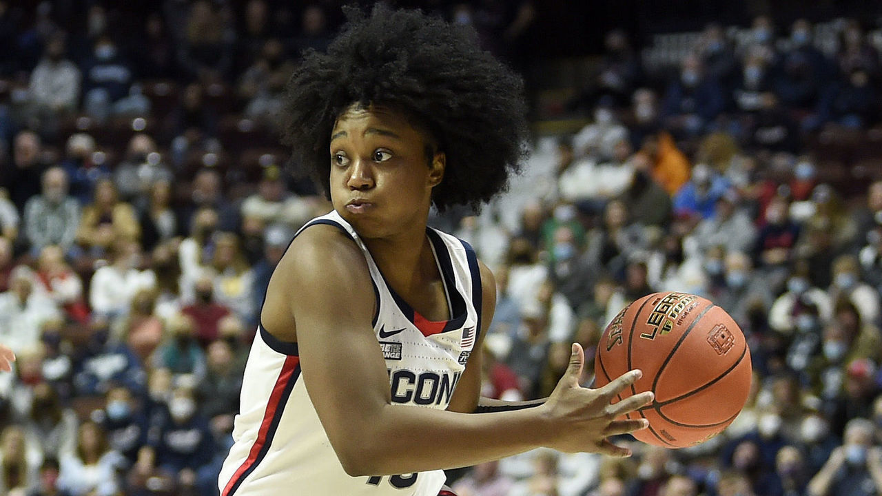 UNCASVILLE, CONNECTICUT - DECEMBER 19: Christyn Williams #13 of the Connecticut Huskies handles the ball against Mykasa Robinson #5 of the Louisville Cardinals in the Basketball Hall of Fame Women's Showcase at Mohegan Sun Arena on December 19, 2021 in Uncasville, Connecticut.