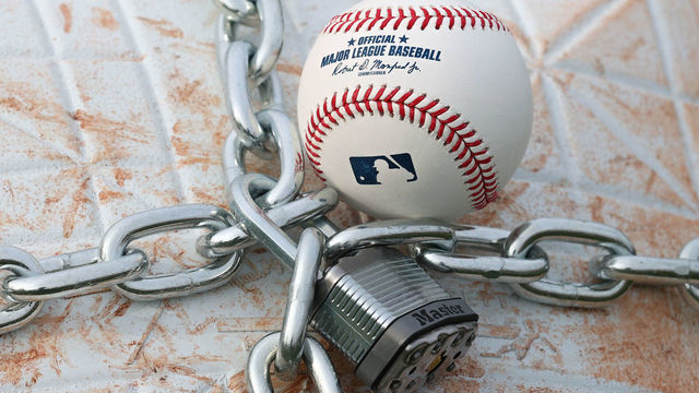 LINCROFT, NJ - JANUARY 28: An official MLB baseball sits on top of an MLB game-used base with a lock and chain around it to represent the lockout between Major League Baseball (MLB) and the Major League Baseball Players Association (MLBPA) on January 28, 2022 in Lincroft, New Jersey.