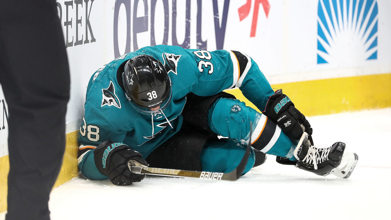 SAN JOSE, CA - FEBRUARY 26: Mario Ferraro #38 of the San Jose Sharks grabs his ankle after crashing into the wall against the Boston Bruins at SAP Center on February 26, 2022 in San Jose, California.