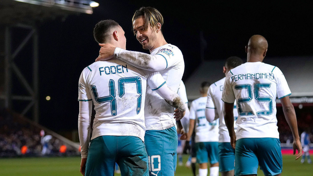 PETERBOROUGH, ENGLAND - MARCH 01: Jack Grealish celebrates with teammate Phil Foden of Manchester City after scoring their team's second goal during the Emirates FA Cup Fifth Round match between Peterborough United and Manchester City at ABAX Stadium on March 01, 2022 in Peterborough, England.