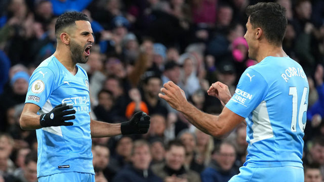 MANCHESTER, ENGLAND - MARCH 06: Riyad Mahrez of Manchester City celebrates their sides third goal with team mate Rodrigo during the Premier League match between Manchester City and Manchester United at Etihad Stadium on March 06, 2022 in Manchester, England.