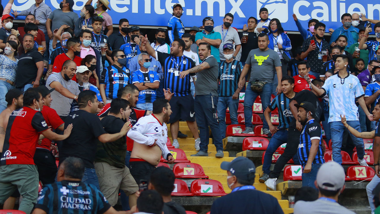 QUERETARO, MEXICO - MARCH 05: Fans of Atlas and Queretaro fight in the stands during the 9th round match between Queretaro and Atlas as part of the Torneo Grita Mexico C22 Liga MX at La Corregidora Stadium on March 5, 2022 in Queretaro, Mexico. The match was suspended on the 60th minute due to violent fights between fans that resulted in many injured.