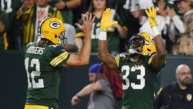 GREEN BAY, WISCONSIN - SEPTEMBER 20: Aaron Jones #33 of the Green Bay Packers celebrates a touchdown against the Detroit Lions with teammate Aaron Rodgers #12 during the first half at Lambeau Field on September 20, 2021 in Green Bay, Wisconsin.