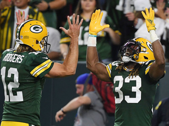 GREEN BAY, WISCONSIN - SEPTEMBER 20: Aaron Jones #33 of the Green Bay Packers celebrates a touchdown against the Detroit Lions with teammate Aaron Rodgers #12 during the first half at Lambeau Field on September 20, 2021 in Green Bay, Wisconsin.