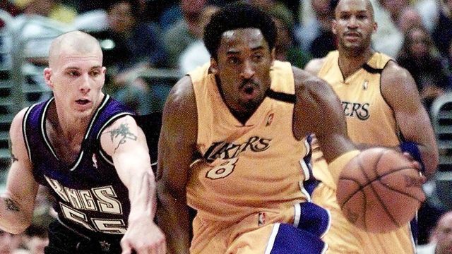 Kobe Bryant (C) of the Los Angeles Lakers dribbles down court against Jason Williams (L) of the Sacramento Kings during the 4th quarter of game five of the first round of the NBA Western Conference in Los Angeles 05 May, 2000. The Lakers defeated the Kings 113-86 to advance to the Western Conference semi-finals against the Phoenix Suns. In the background is Ron Harper of the Lakers. (ELECTRONIC IMAGE) AFP PHOTO/VINCE BUCCI