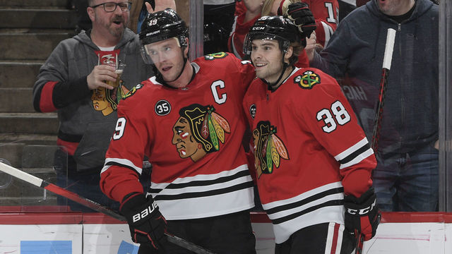 CHICAGO, ILLINOIS - MARCH 08: Jonathan Toews #19 and Brandon Hagel #38 of the Chicago Blackhawks celebrate after Toews scored against the Anaheim Ducks in the first period at United Center on March 08, 2022 in Chicago, Illinois.