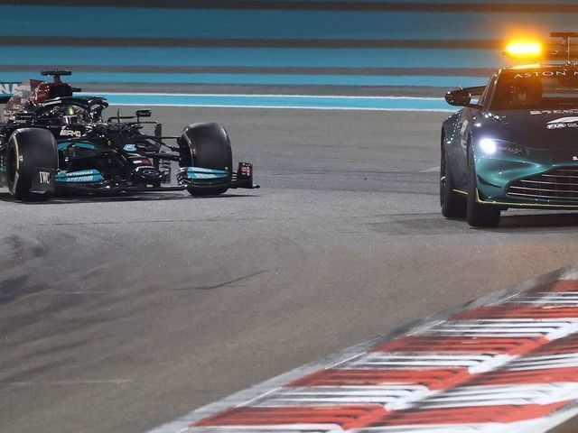 TOPSHOT - Mercedes' British driver Lewis Hamilton drives behind the safety car at the Yas Marina Circuit during the Abu Dhabi Formula One Grand Prix on December 12, 2021.