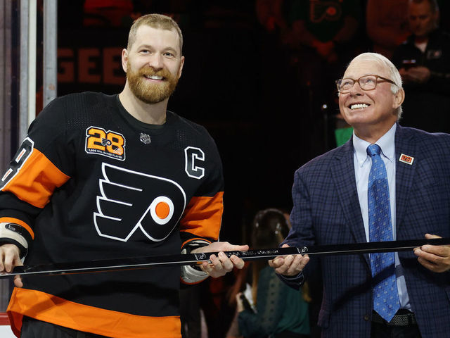 PHILADELPHIA, PENNSYLVANIA - MARCH 17: Claude Giroux #28 of the Philadelphia Flyers is awarded with a commemorative stick by NHL Hall of Fame member and former Flyer Bobby Clarke before a game between the Philadelphia Flyers and the Nashville Predators at Wells Fargo Center on March 17, 2022 in Philadelphia, Pennsylvania. Giroux is playing in his 1,000th-career NHL game.