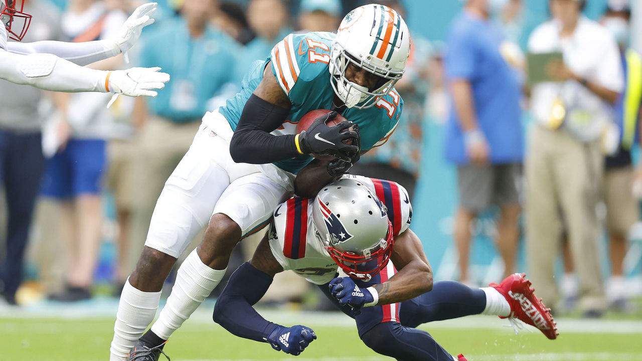 MIAMI GARDENS, FLORIDA - JANUARY 09: J.C. Jackson #27 of the New England Patriots tackles DeVante Parker #11 of the Miami Dolphins during the first quarter at Hard Rock Stadium on January 09, 2022 in Miami Gardens, Florida.