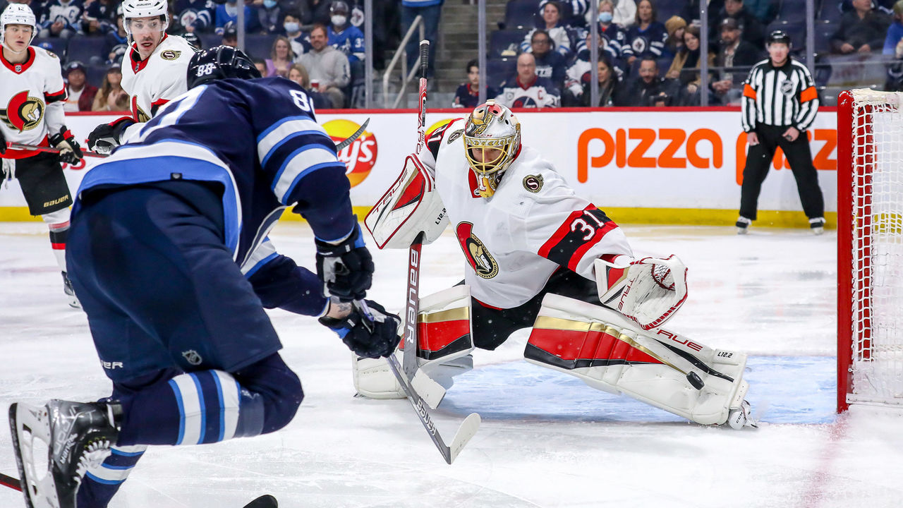 WINNIPEG, MB - MARCH 24: Goaltender Anton Forsberg #31 of the Ottawa Senators makes a pad save on a shot by Nate Schmidt #88 of the Winnipeg Jets during second period action at the Canada Life Centre on March 24, 2022 in Winnipeg, Manitoba, Canada.