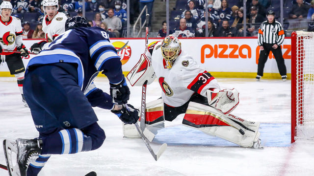 WINNIPEG, MB - MARCH 24: Goaltender Anton Forsberg #31 of the Ottawa Senators makes a pad save on a shot by Nate Schmidt #88 of the Winnipeg Jets during second period action at the Canada Life Centre on March 24, 2022 in Winnipeg, Manitoba, Canada.
